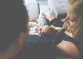 parents cuddling their new born baby