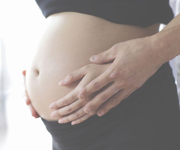 Mother and partner holding baby bump