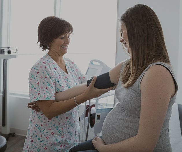 Midwife taking pregnant mother’s blood pressure