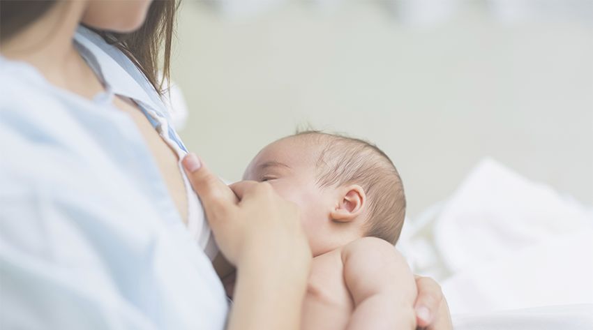 a mother breastfeeding newborn baby