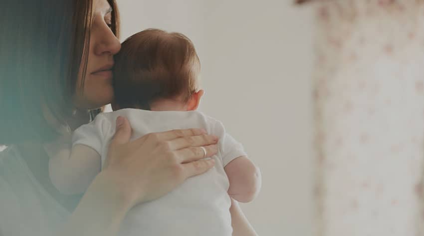 Woman burping baby 