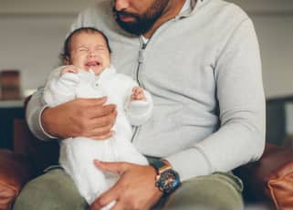 Man holding crying baby