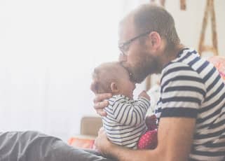 Man kissing baby on the forehead