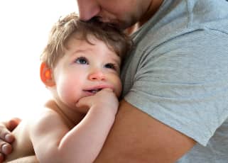 young boy cuddled up to his father