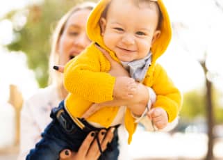 Mother holding a baby in a park