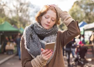 Stressed woman holding a phone with her eyes closed