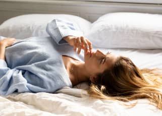 Woman laying in bed looking pensive