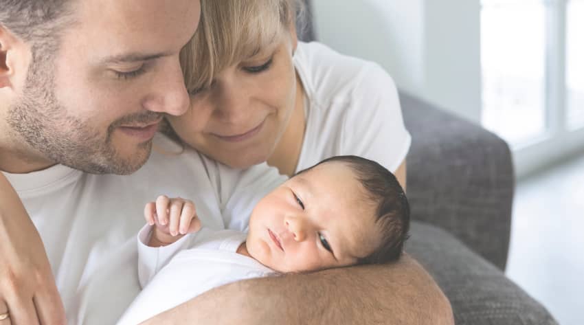 Parents looking lovingly at newborn