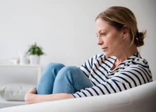 Woman sat on the sofa looking depressed