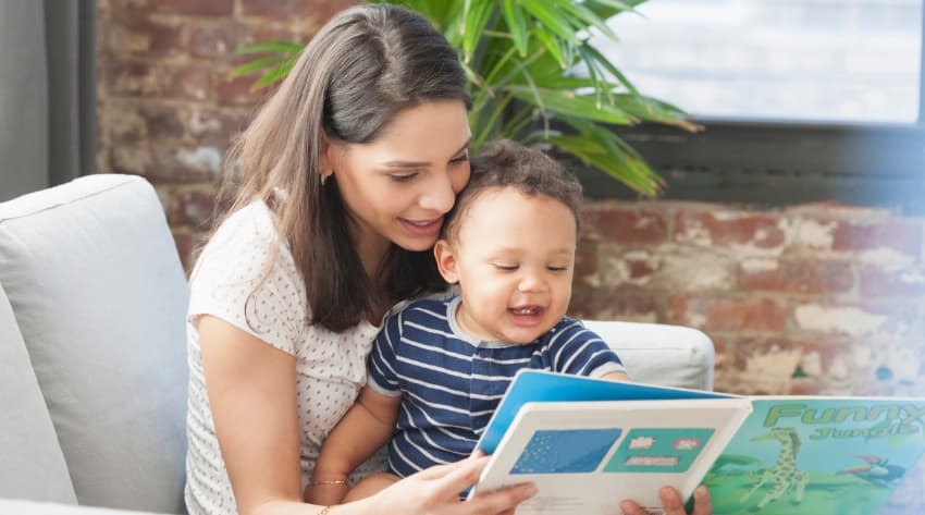 Mum encouraging baby to talk and read with a book