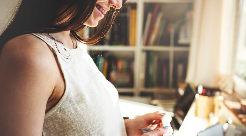 woman smiling at positive pregnancy test