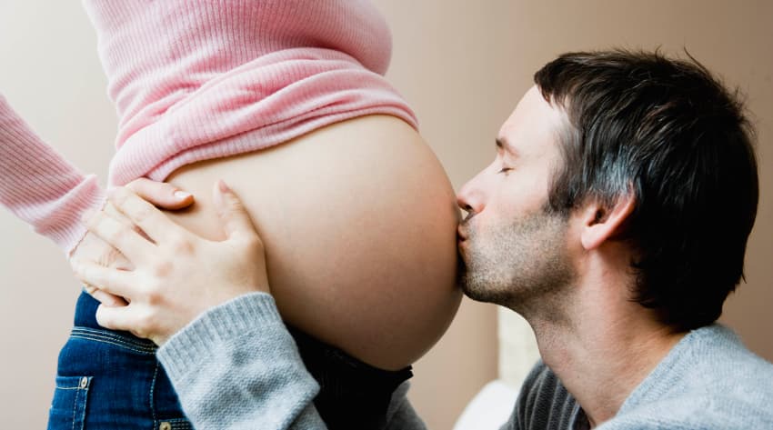Man kissing pregnant woman’s belly