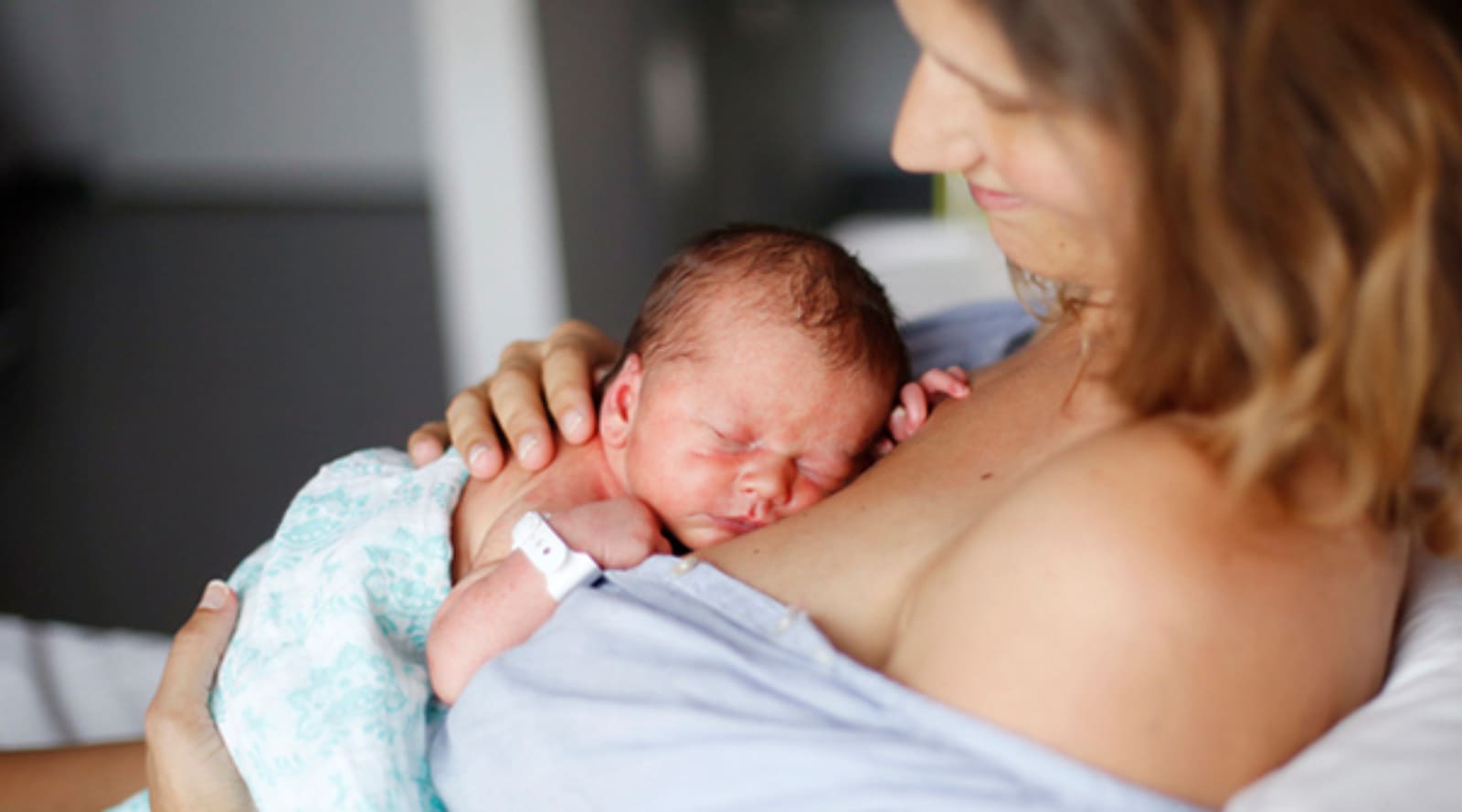 A mother holding her newborn child against her chest