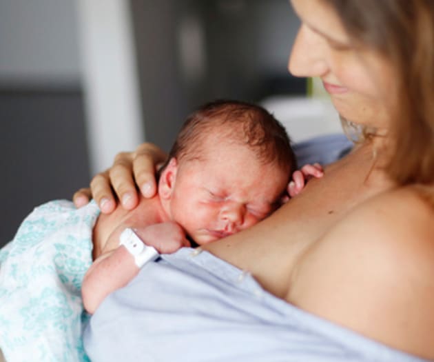A mother holding her newborn child against her chest