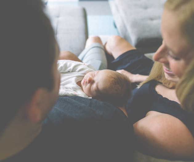 parents cuddling their new born baby