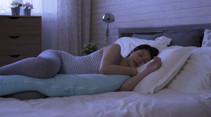 39 weeks pregnant mother sleeping with a pregnancy pillow