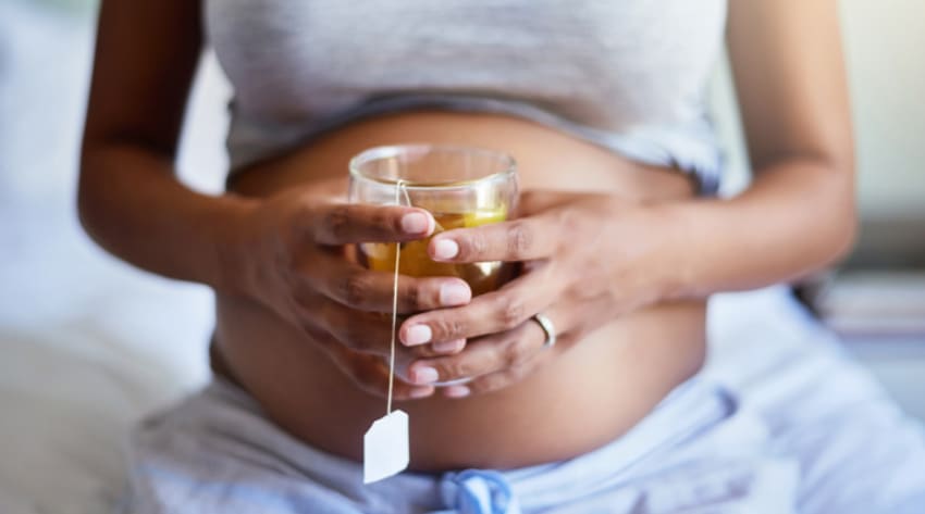 Pregnant mother holding a cup of camomile tea
