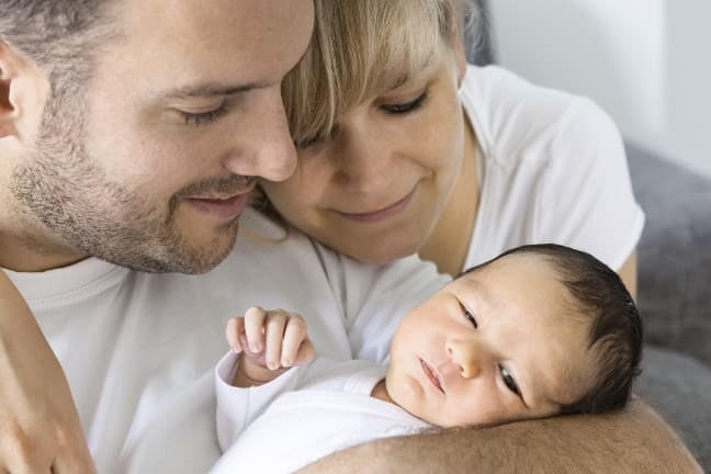 Parents holding their child at home
