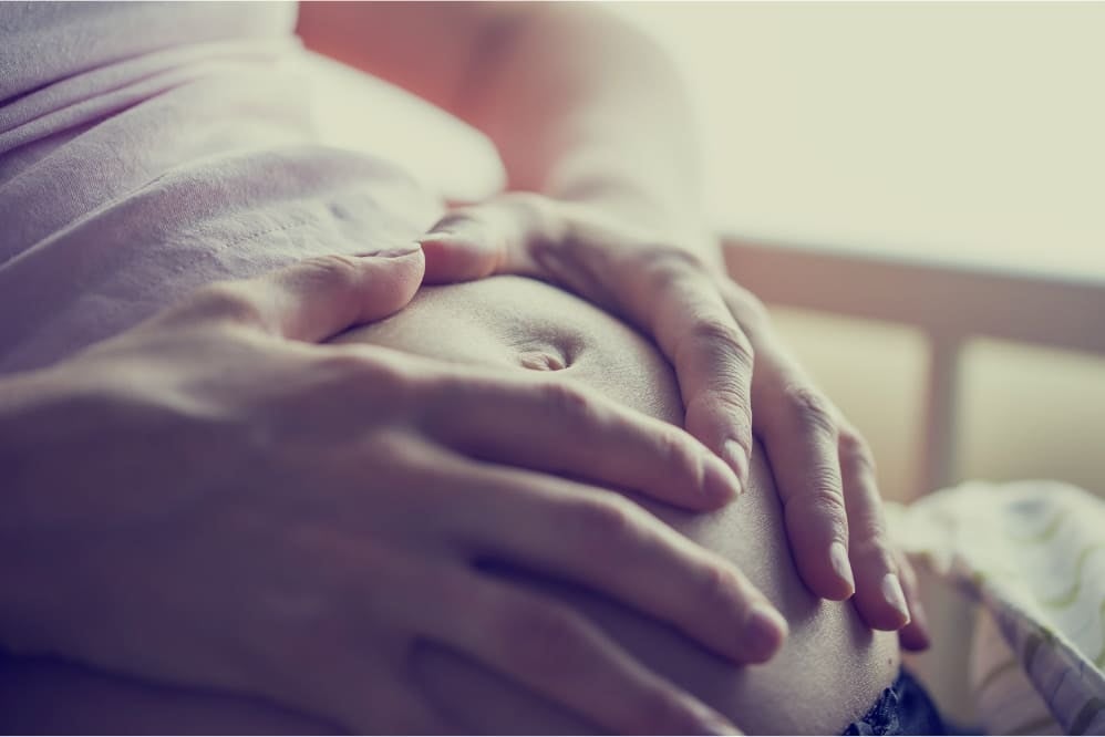 A pregnant woman holding her stomach