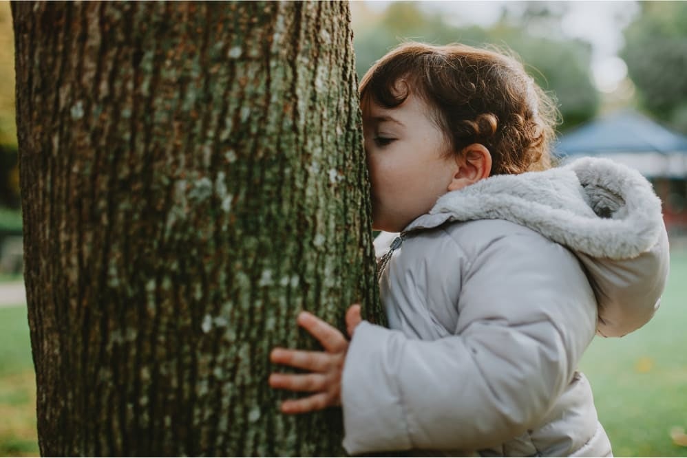 Toddler kissing a tree