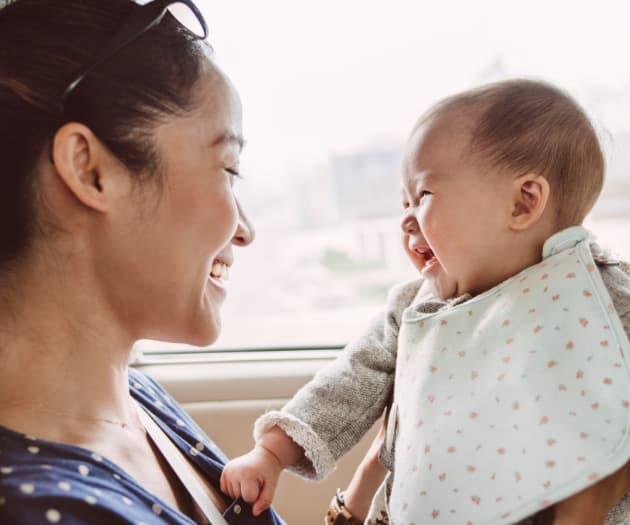 Mother holding baby and mother and baby laughing