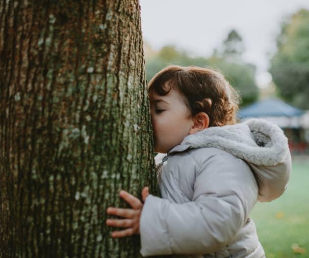 Toddler kissing a tree